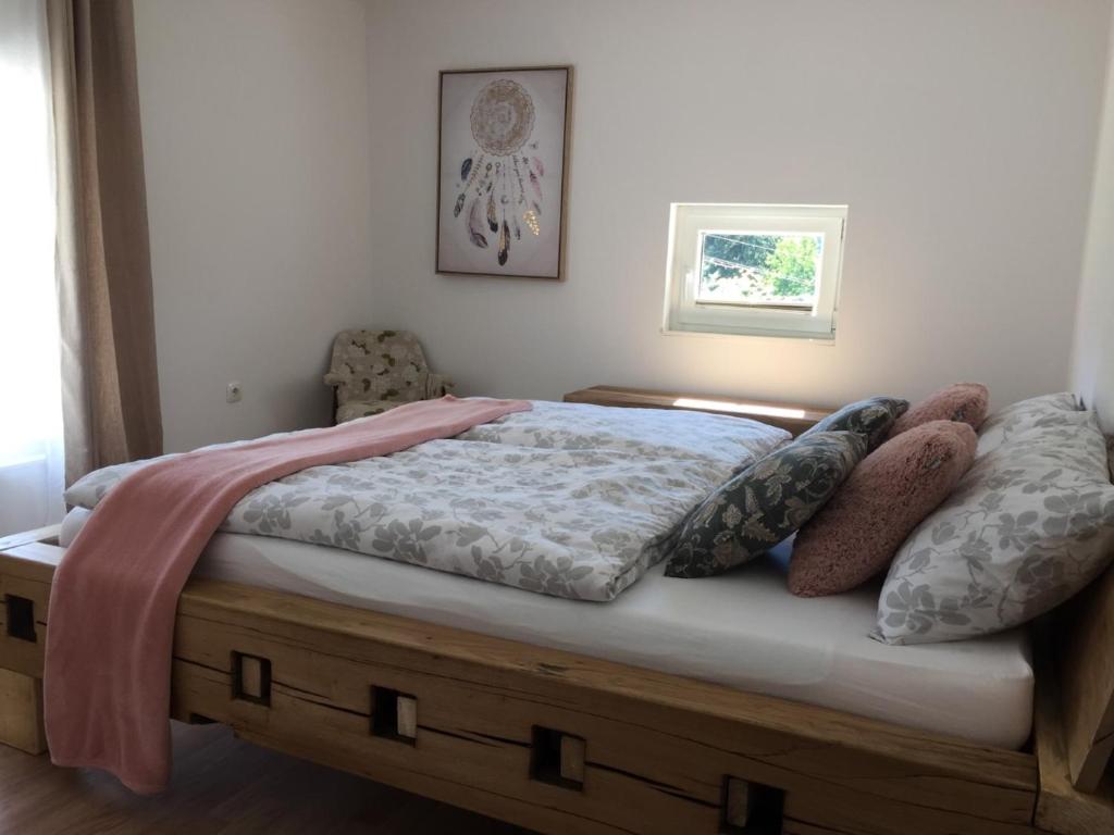 een slaapkamer met een bed met kussens erop bij Hillside Bio Resort Apartment with Mountain View in Prebold