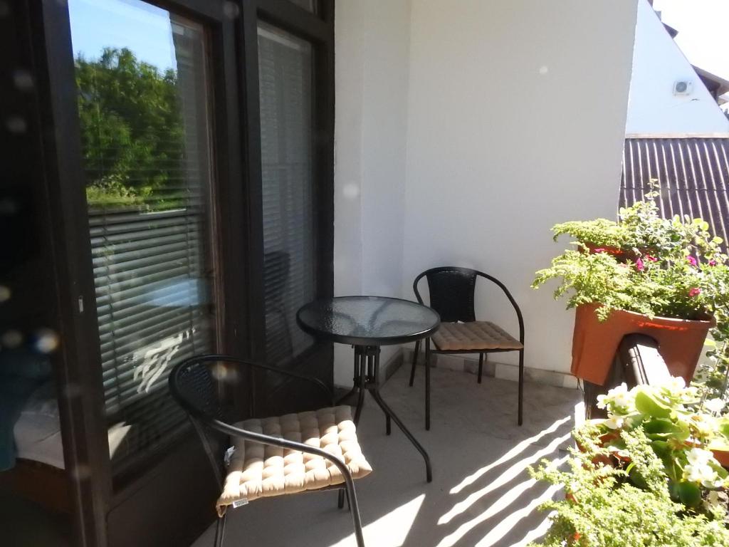 eine Terrasse mit 2 Stühlen und einem Tisch auf dem Balkon in der Unterkunft Haus Gizella in Harkány