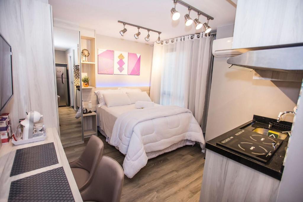 a bedroom with a white bed in a room at Studio Completo no Centro de Curitiba - ALL1021 in Curitiba