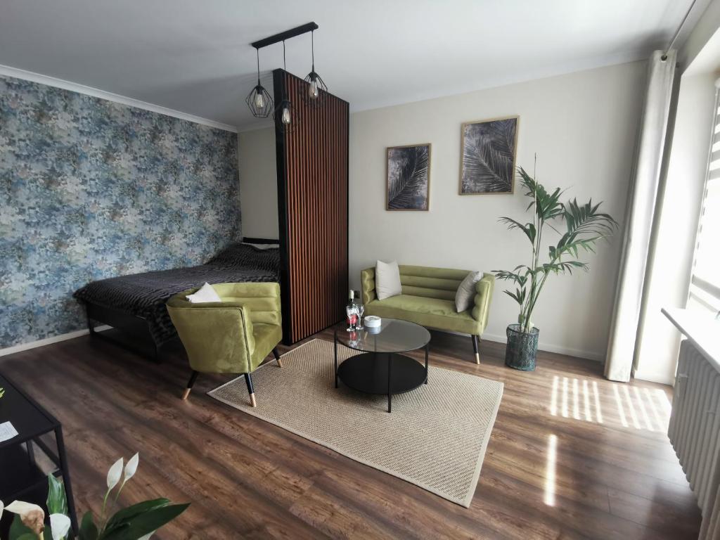 チェンストホヴァにあるApartament Złoty w Centrum Miastaのベッドルーム1室(ベッド1台、椅子、テーブル付)