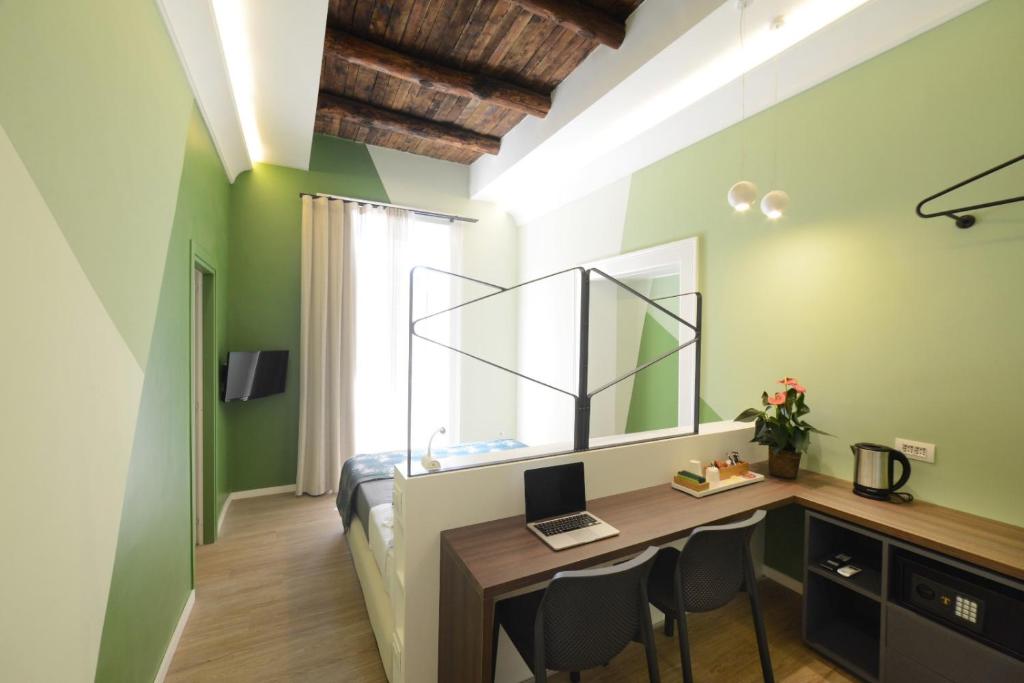 a bedroom with green walls and a desk with a computer at Mediterra in Castellammare di Stabia