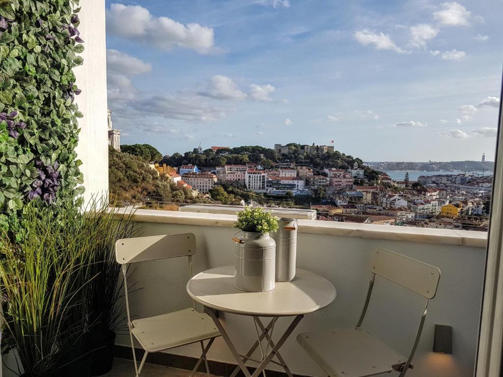 d'une petite table et de chaises sur un balcon avec vue. dans l'établissement Best view in Lisbon!, à Lisbonne