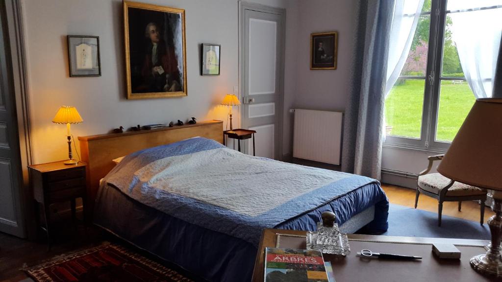 a bedroom with a bed with a blue comforter at La Violiere in Rouziers-de-Touraine