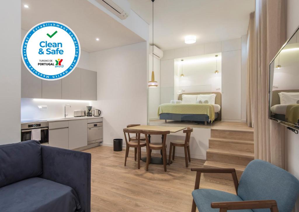 a kitchen and a living room with a table and chairs at Chiado Cosmopolitan Apartments in Lisbon