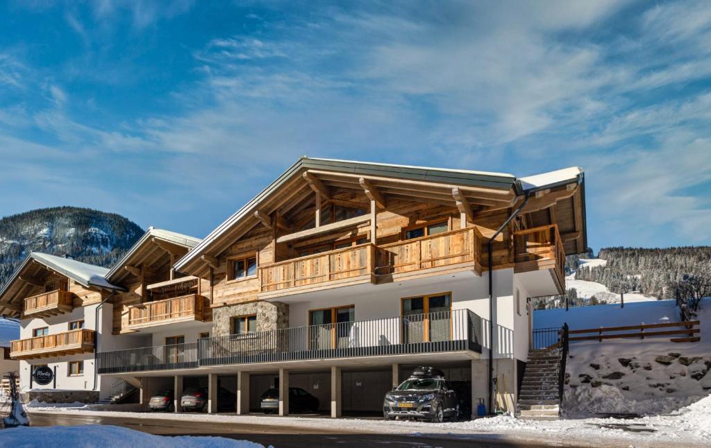a building in the mountains with snow on the ground at CHALET MONTIS in Flachau