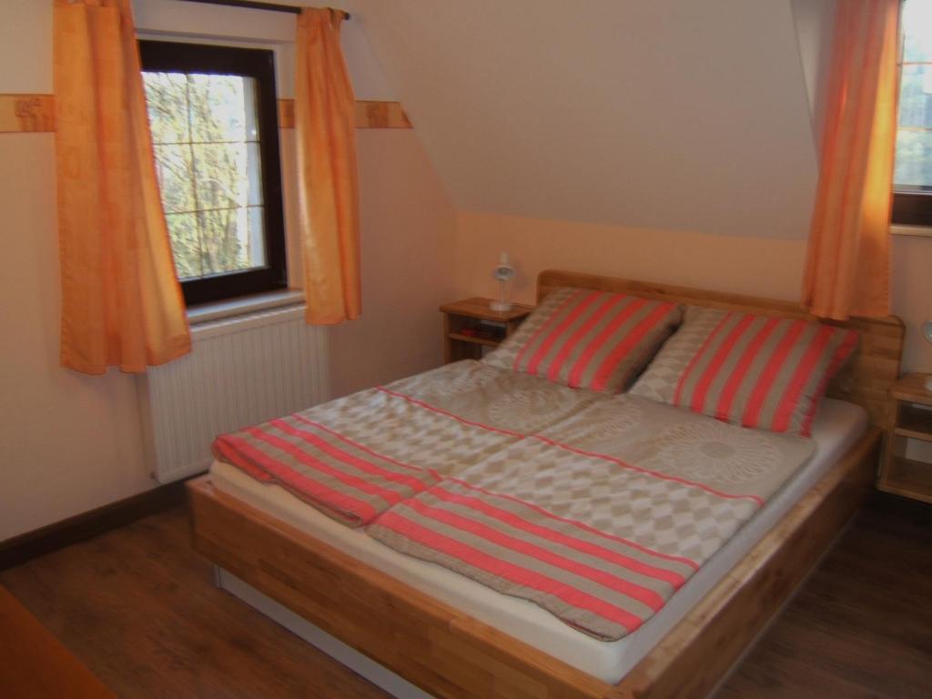 Bett in einem kleinen Zimmer mit Fenster in der Unterkunft Doppelzimmer Liliensteinblick 1.OG in Bad Schandau