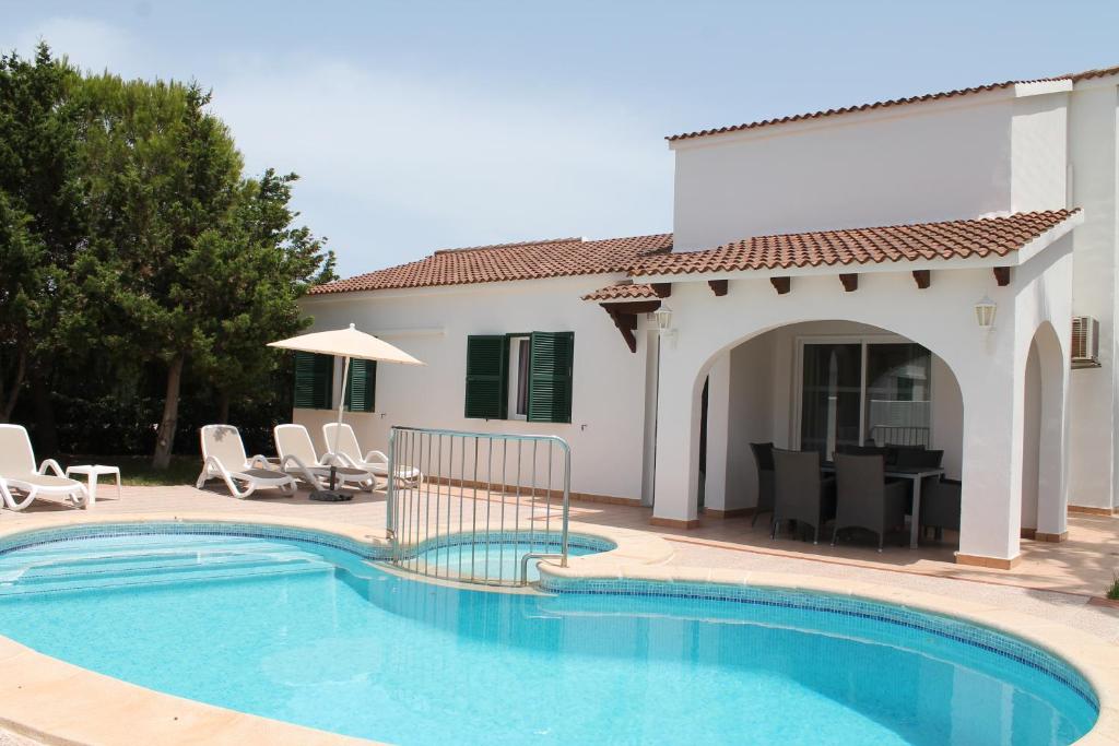 una piscina di fronte a una villa di Villa RAQUEL a Cala'n Forcat