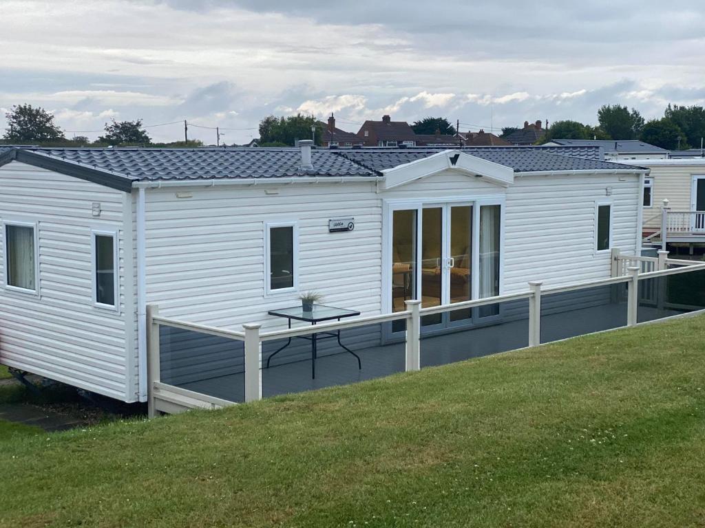 a white house with a deck on a lawn at Luxury Holiday Home in Anderby Creek in Anderby