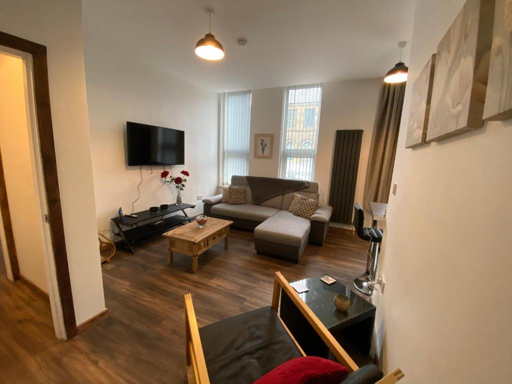 a living room with a couch and a tv at Self catering Skipton town centre apartment in Skipton