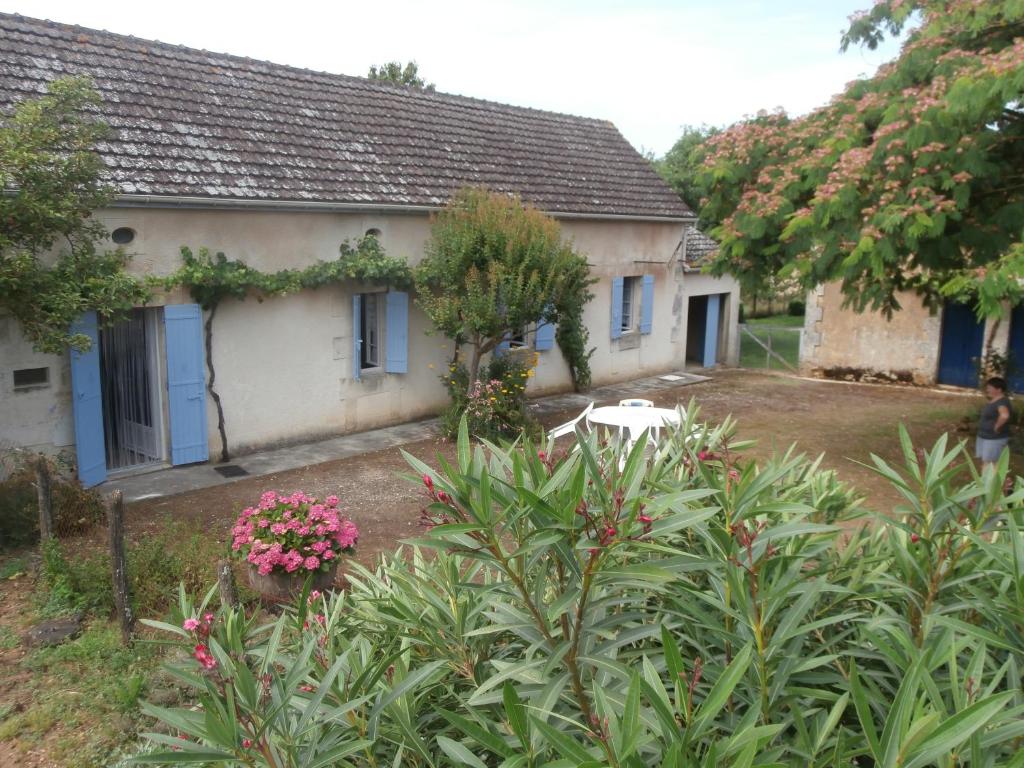 uma casa com muitas plantas à frente dela em La grange de Tombeloly em Clermont-de-Beauregard