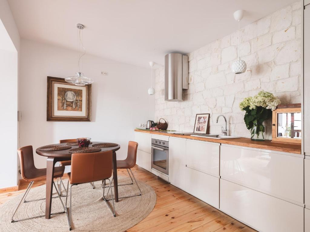 a kitchen with a table and a kitchen with white cabinets at Esterka in Kazimierz Dolny