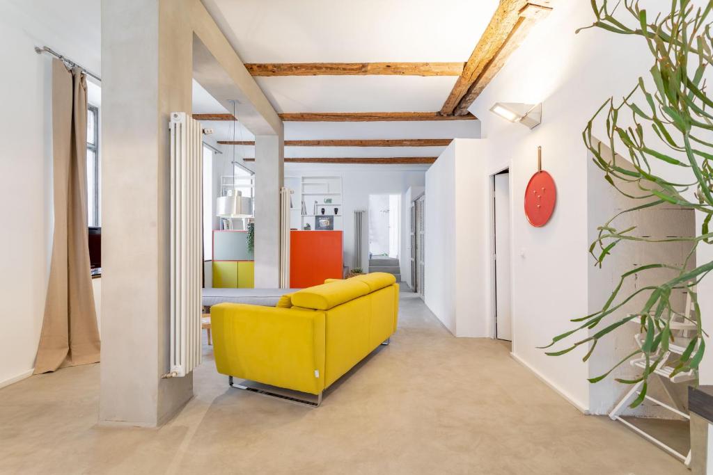 ein gelbes Sofa in einem Zimmer mit weißen Wänden in der Unterkunft Chic et moderne in Marseille