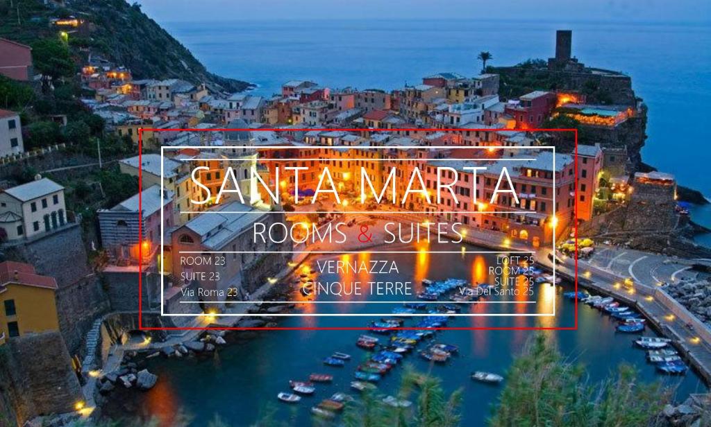 a view of a city at night with a sign at Santa Marta Rooms - Via Roma 23 in Vernazza