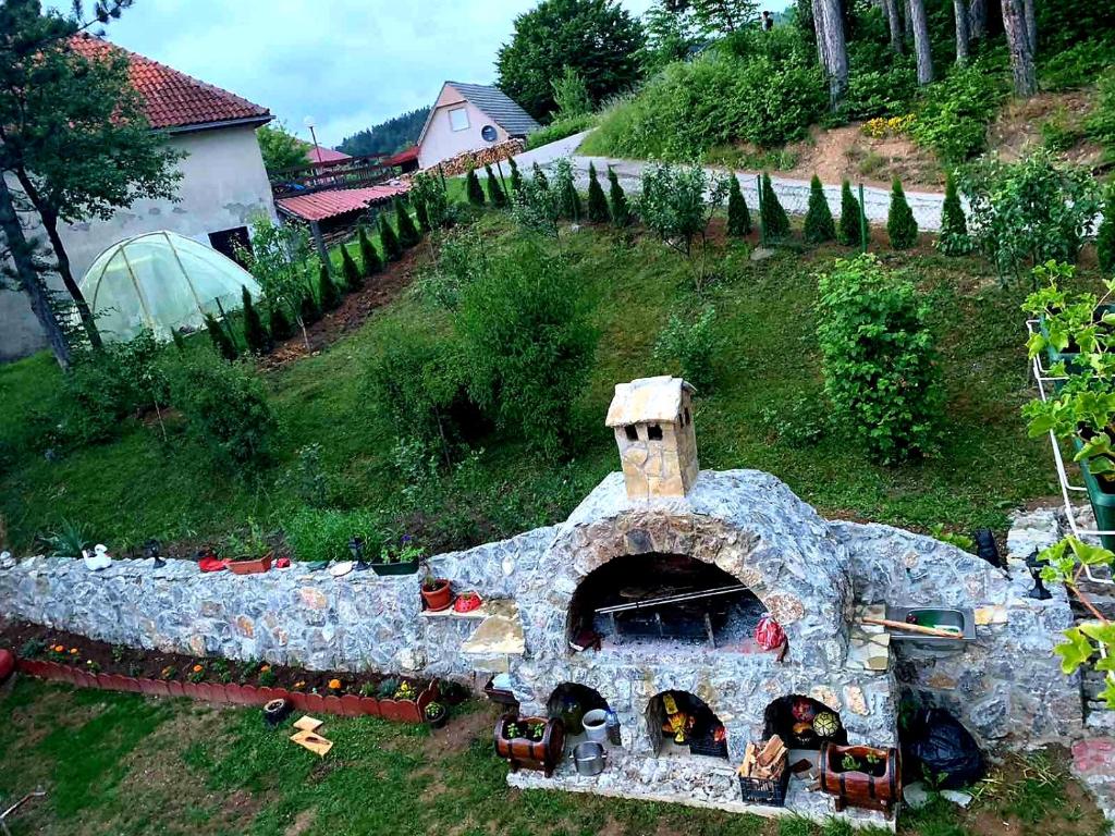 a garden with a stone oven in the grass at Apartments Popovic in Kola&scaron;in