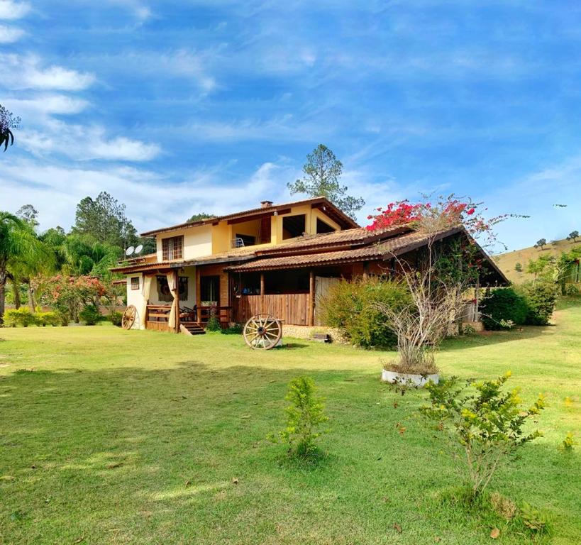 een huis in een veld met een grasveld bij Recanto Roça Grande in Cunha