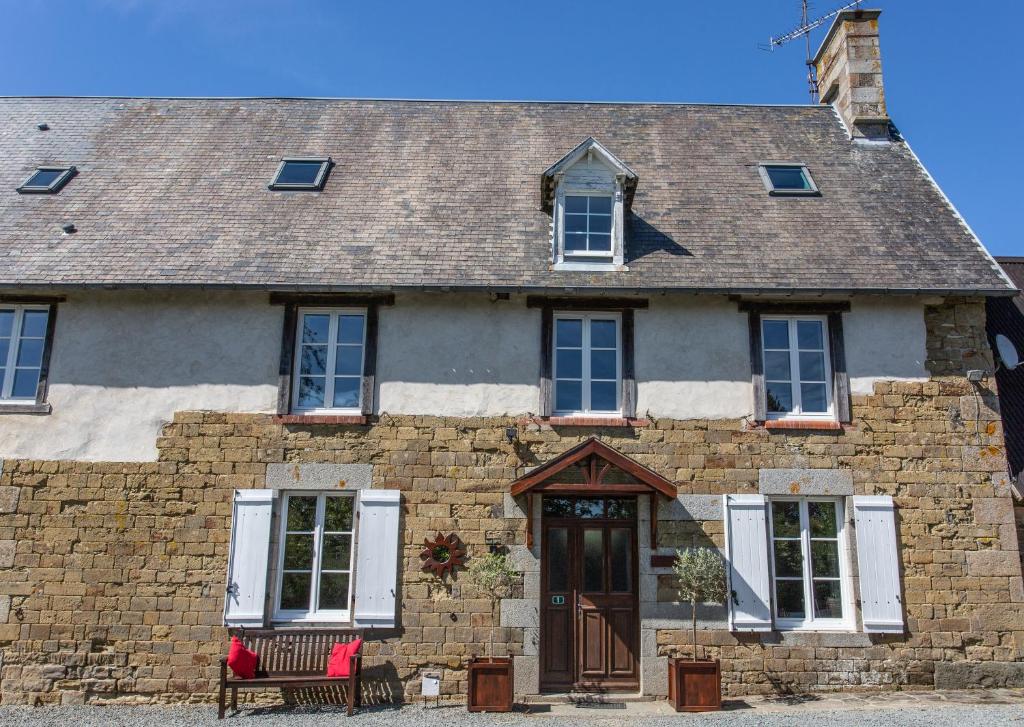 una antigua casa de piedra con techo marrón en La Maison du Chene, en Percy
