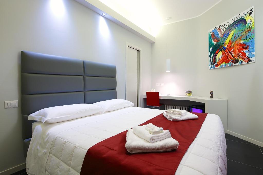 ein Schlafzimmer mit einem großen Bett mit Handtüchern darauf in der Unterkunft NearHome Smart Suites Guest House in Rom