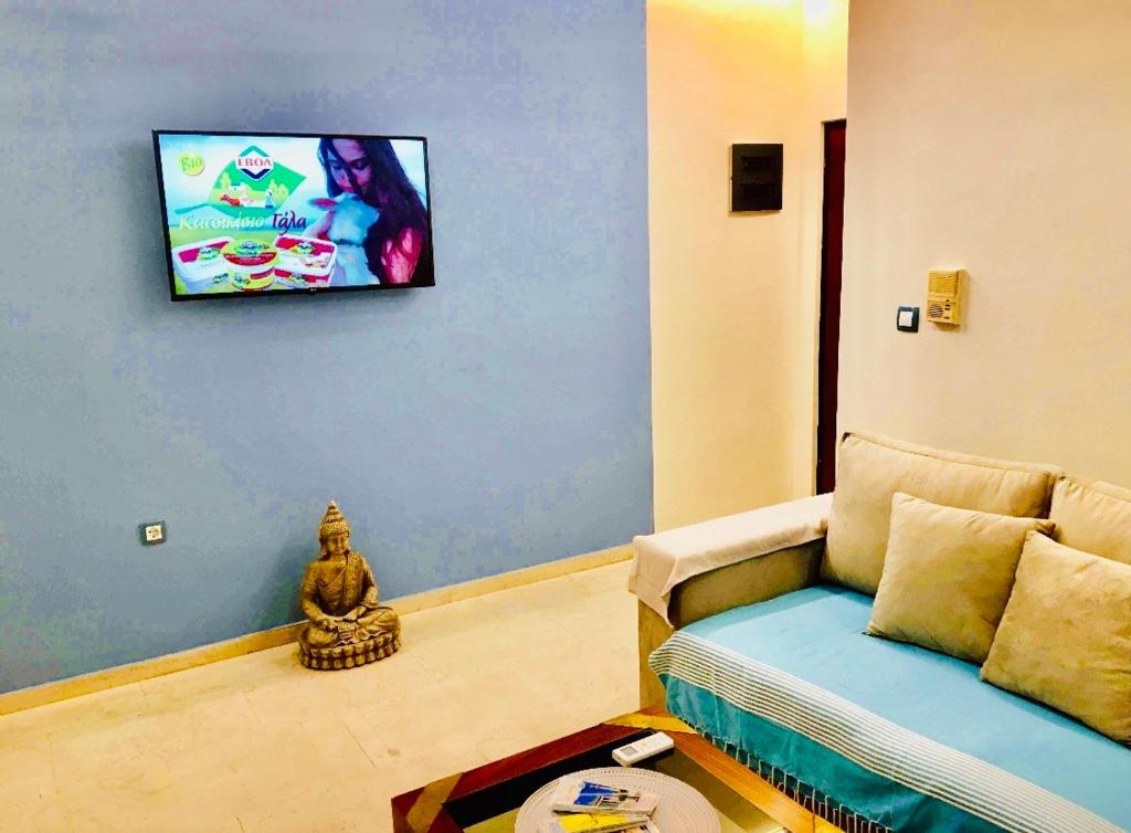 salon z kanapą i telewizorem z płaskim ekranem w obiekcie Piraeus Blue Grand Suite di Giorgio 10 mins from the port. w Pireusie