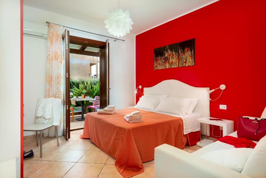 サン・ヴィート・ロ・カーポにあるB&B Armonieの赤いベッドルーム(ベッド1台、テーブル付)