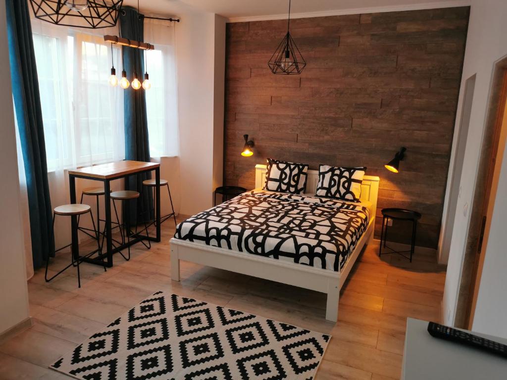 a bedroom with a bed and a table in it at Central Park Studio Petrosani in Petroşani