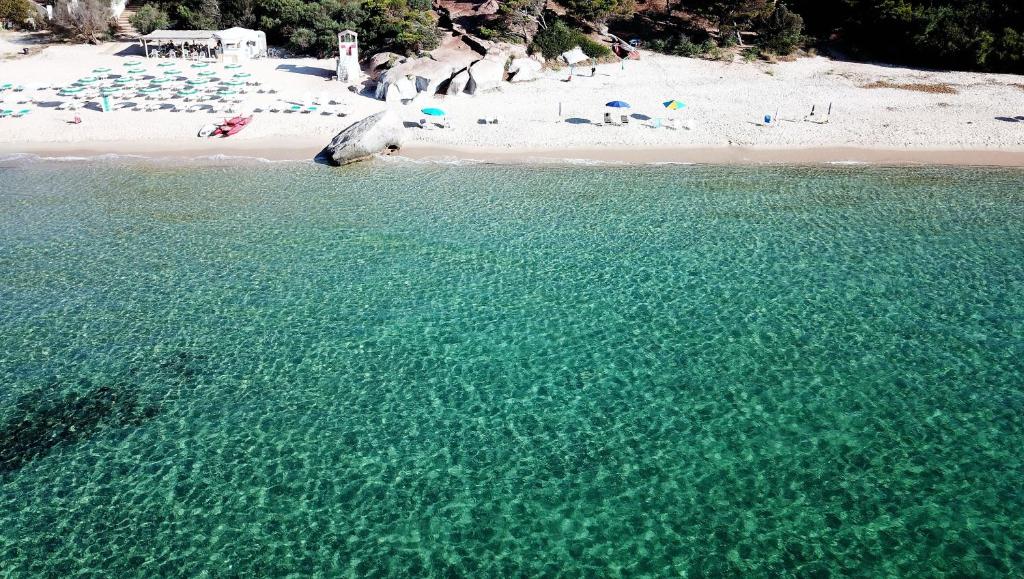 widok z lotu ptaka na plażę z ludźmi w wodzie w obiekcie Villetta Graziosa sul mare ristrutturata w mieście Fort Village