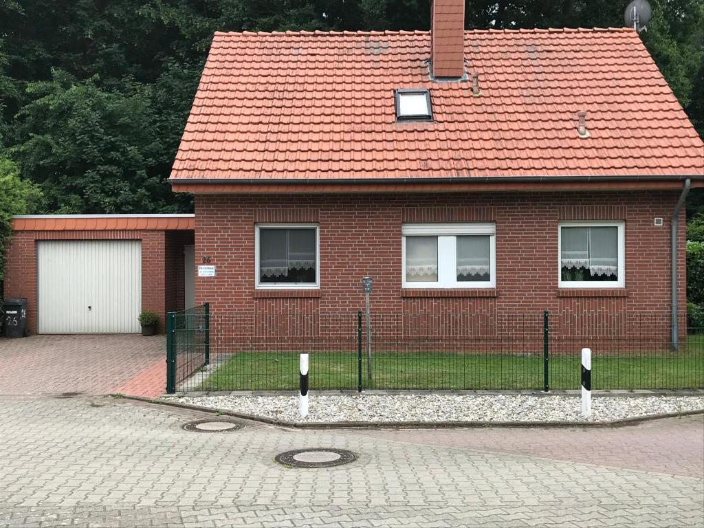 dom z czerwonej cegły z czerwonym dachem w obiekcie Ferienhaus Kleymann w mieście Sögel
