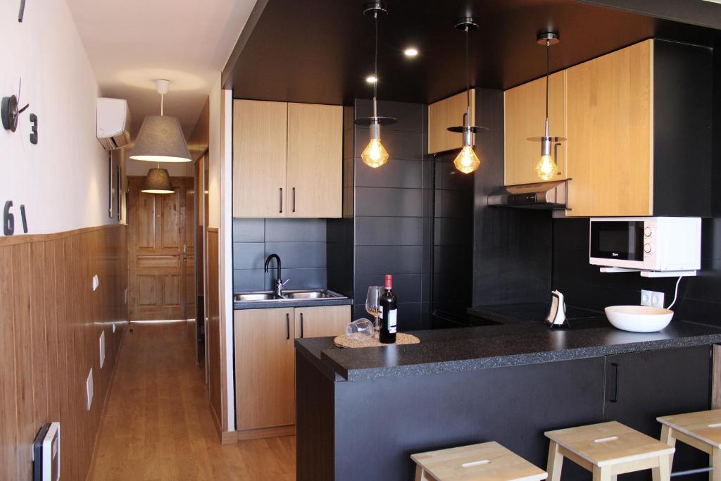 プラヤ・デル・イングレスにあるSiesta Friendly Holiday Homeのキッチン(木製キャビネット、黒いカウンタートップ付)