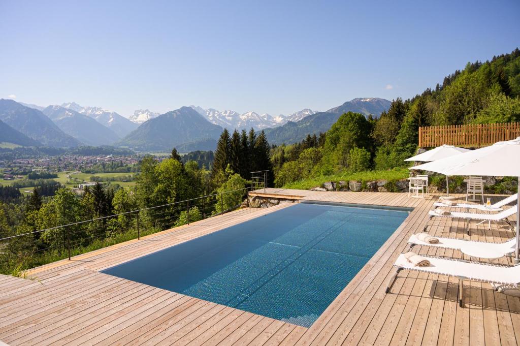 a swimming pool with a view of the mountains at Der Jägersberg in Fischen