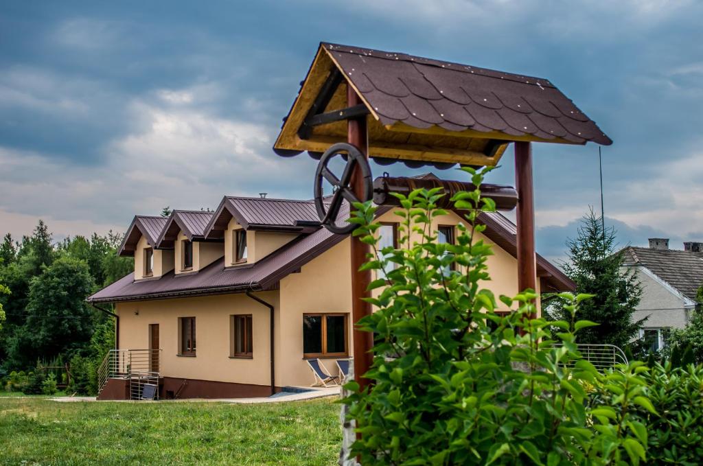 ein Haus mit einem Metalldach darüber in der Unterkunft Ośrodek Wczasowy "Wczasy pod gruszą" in Biecz