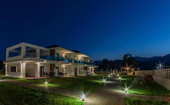 a large white house with lights at night at Katerina's Resort in Sarti
