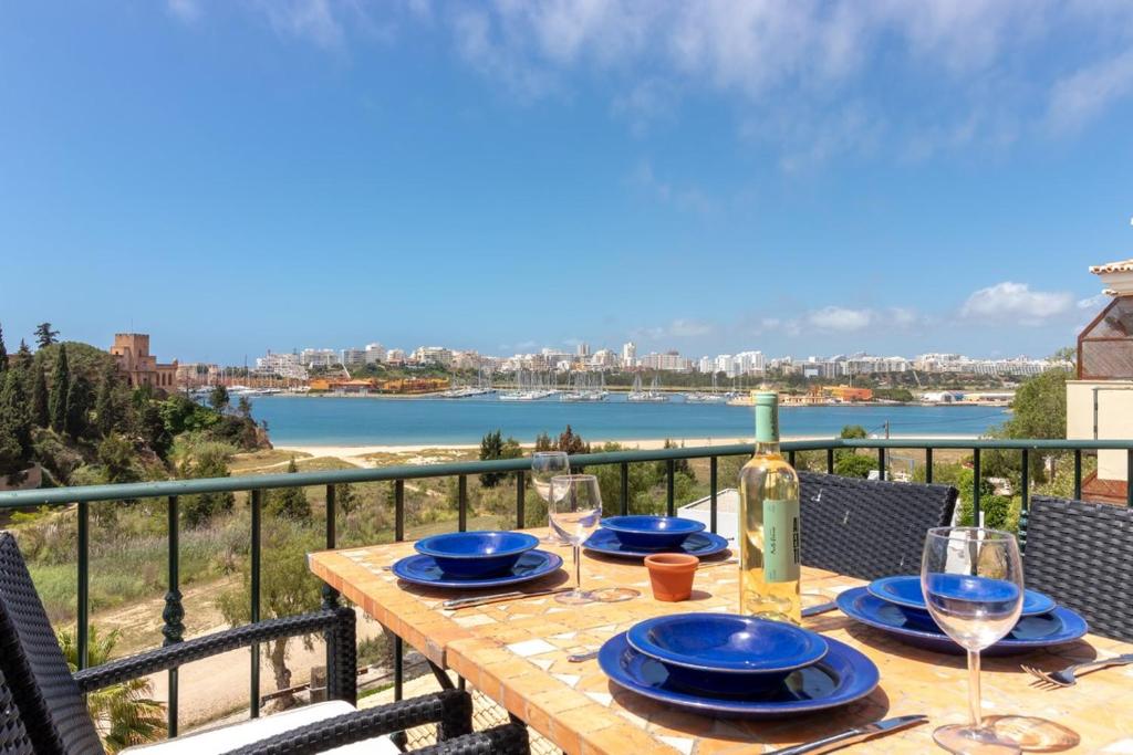 einen Tisch mit Gläsern und eine Flasche Wein auf dem Balkon in der Unterkunft Luxury Townhouse n10 - Front-line Sea views in Ferragudo