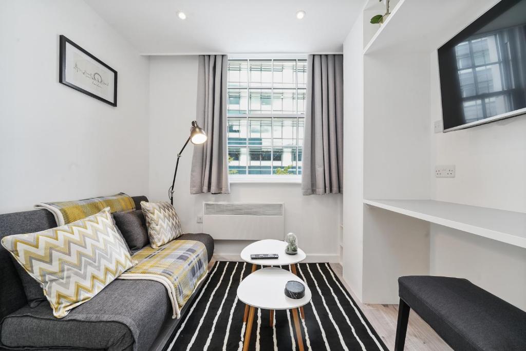 a living room with a couch and a table at Cosy Apartment in the Heart of the City in London