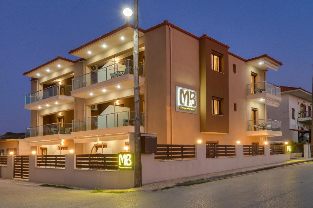 a large building with lights on the side of it at M&B boutique apartments in Nea Roda