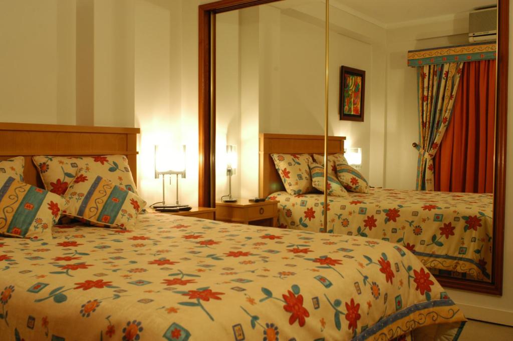 um quarto de hotel com duas camas e duas lâmpadas em Hotel Paraiso em Oliveira do Bairro