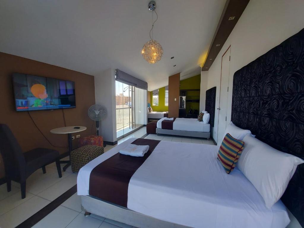 ein Schlafzimmer mit einem großen Bett und ein Wohnzimmer in der Unterkunft Apart Hotel Atenea in Ilo