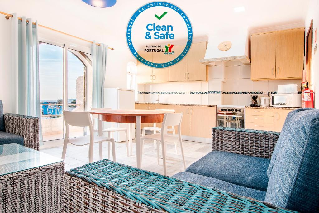 een keuken en een woonkamer met een tafel en stoelen bij Tonel Apartamentos Turisticos in Sagres