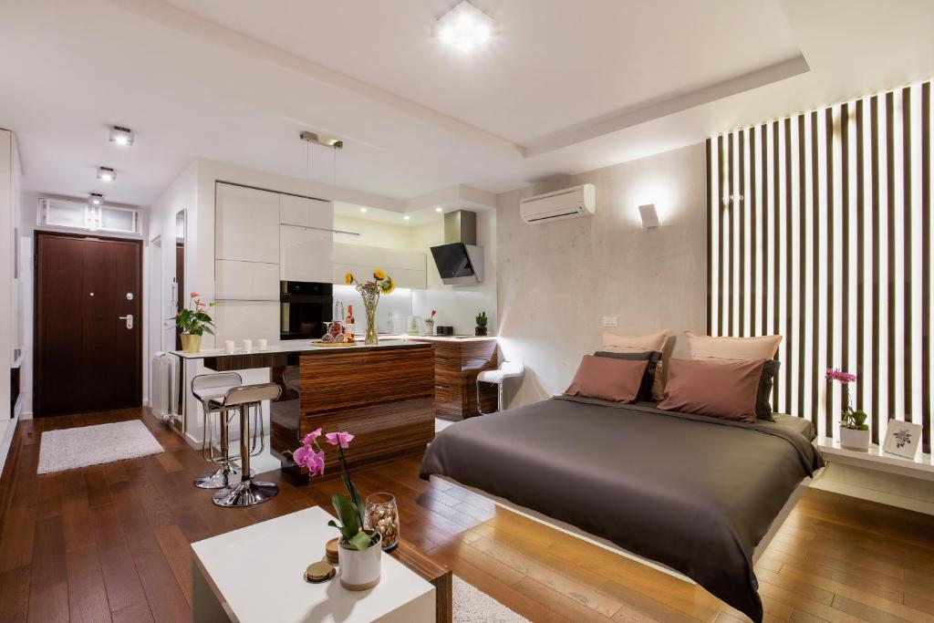 een slaapkamer met een bed, een bureau en een keuken bij Elegant Urban Escape Self Check-In, Free Garage in Belgrade in Belgrado