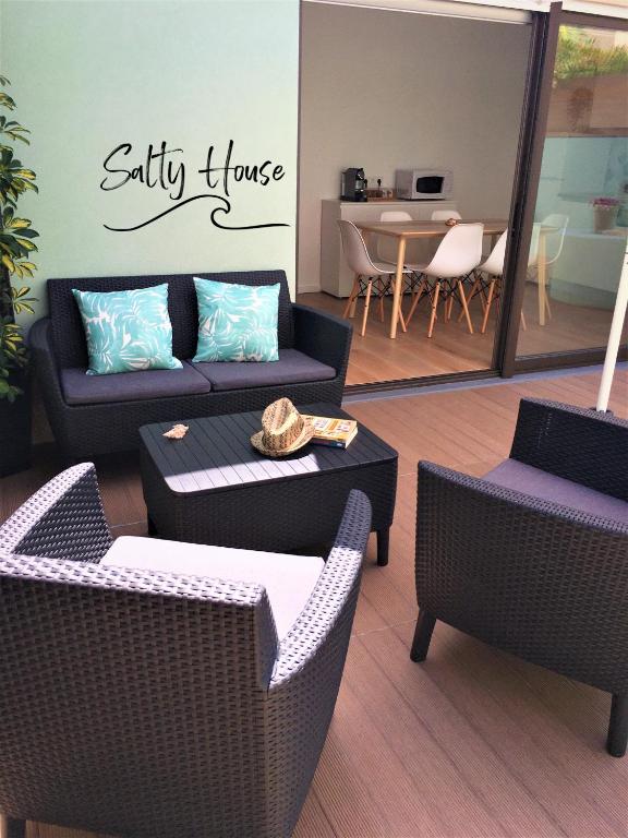 a living room with a couch and chairs and a table at Salty House in Furadouro