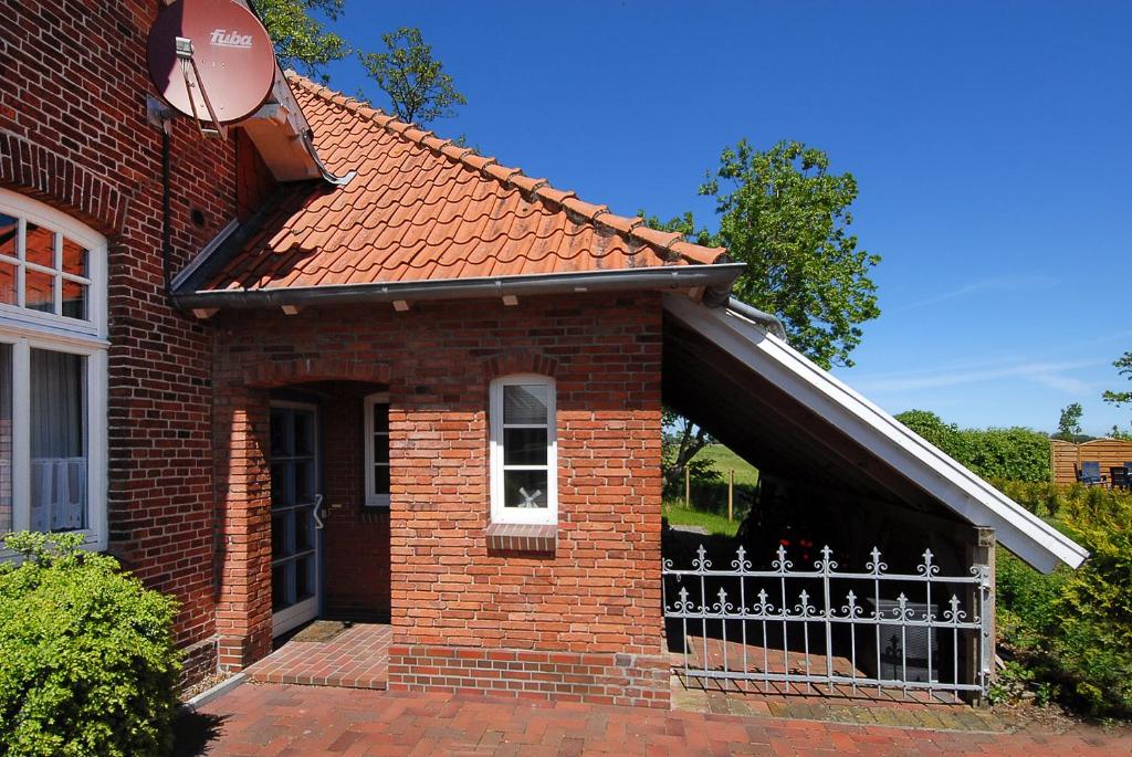 ヴェルドゥムにあるHuus Tideの塀の前のレンガ造りの家