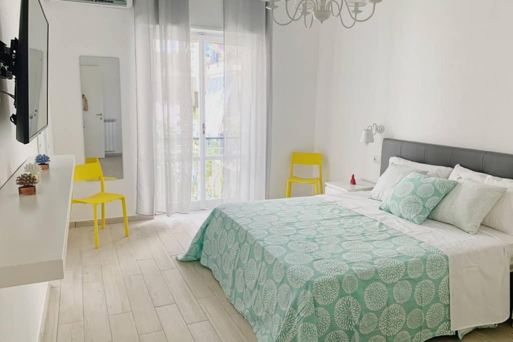 - une chambre avec un lit et deux chaises jaunes dans l'établissement Ladymà Sorrento, à Sorrente