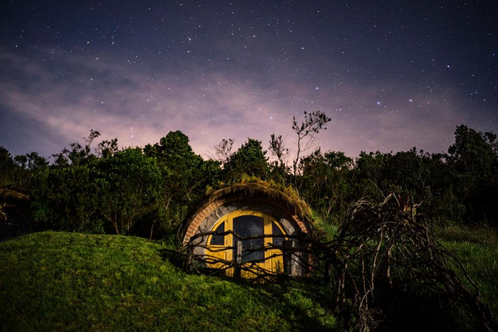 a small house on top of a hill at night at The Secret Garden Cotopaxi in Hacienda Porvenir