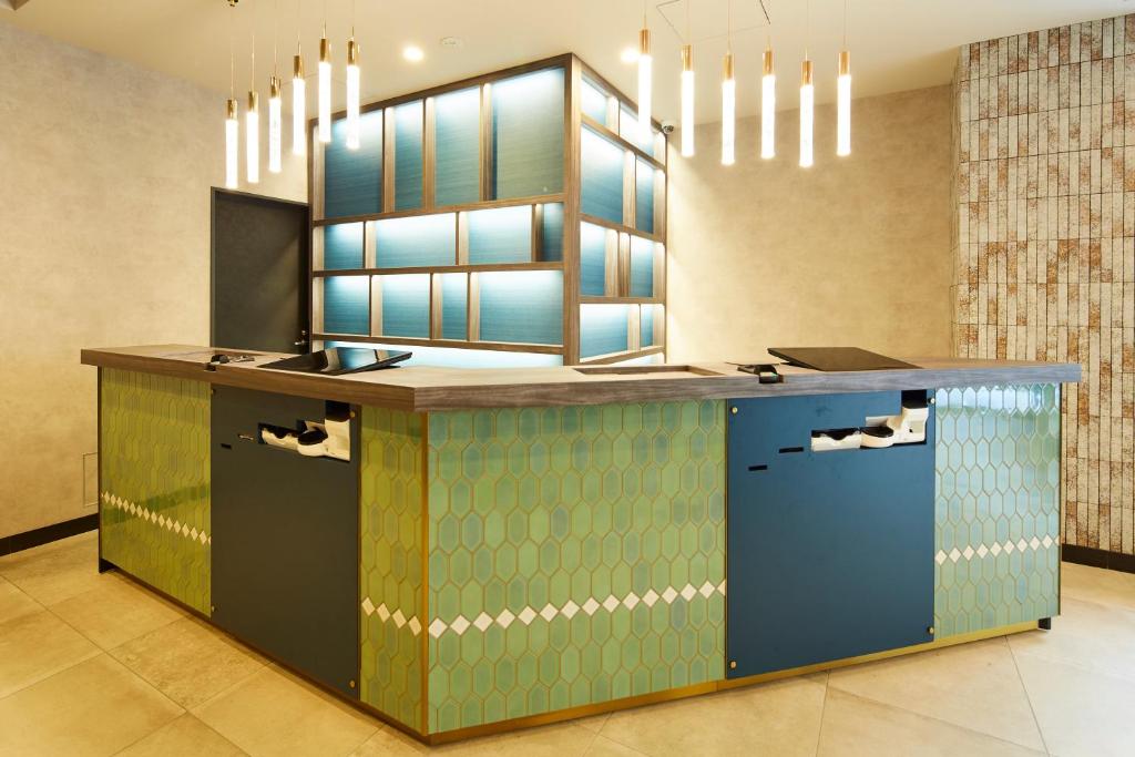 a kitchen with a counter with blue and green at ICI HOTEL Tokyo Hatchobori in Tokyo