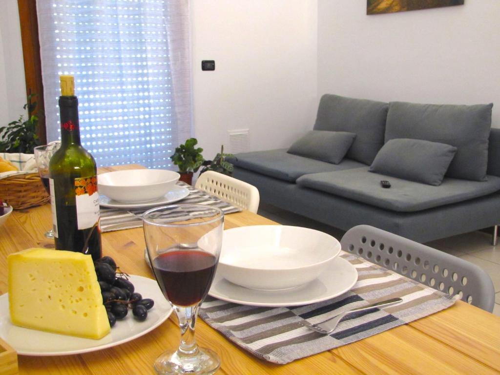 a dining room table with a bottle of wine and cheese at Vicenza City Apartments 1 in Vicenza
