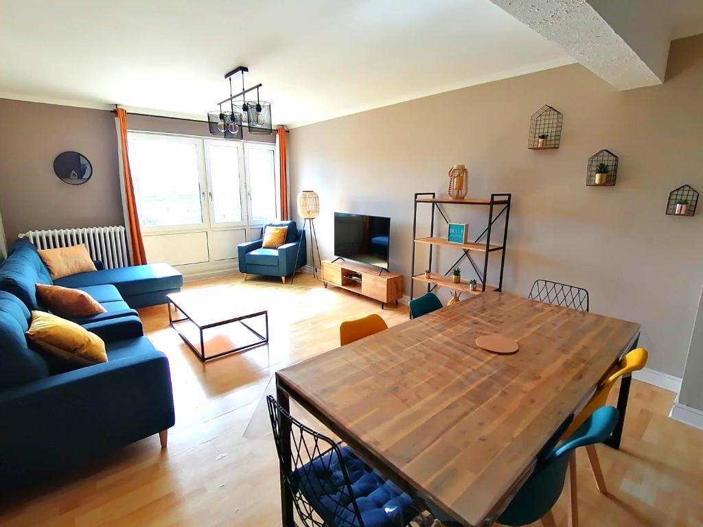 een woonkamer met een houten tafel en een bank bij Face port proche nausicaa avec parking privé gratuit in Boulogne-sur-Mer