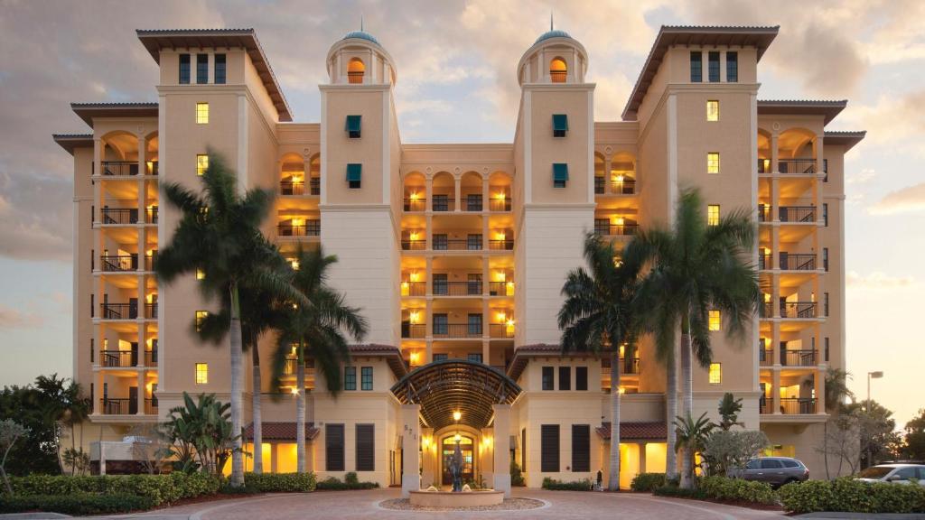 a large building with palm trees in front of it at Holiday Inn Club Vacations Sunset Cove Resort, an IHG Hotel in Marco Island