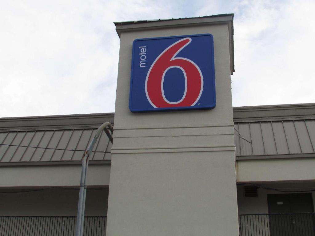 una señal en un poste frente a un edificio en Motel 6 Brookhaven, Ms, en Brookhaven