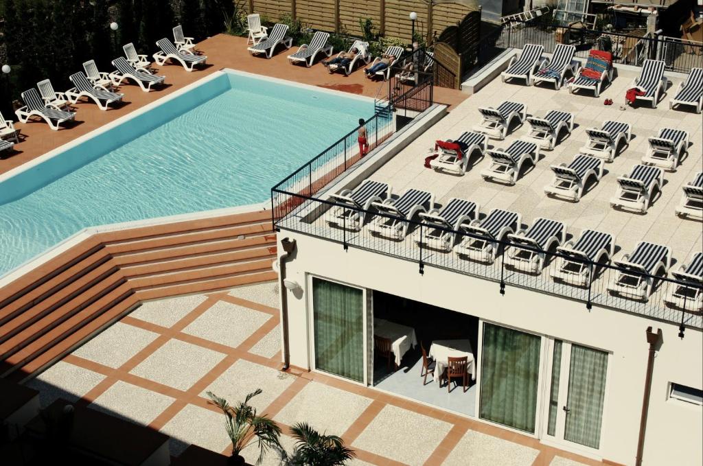 einen Blick über einen Pool mit Liegestühlen in der Unterkunft Hotel Residence Mediterraneo in Diano Marina
