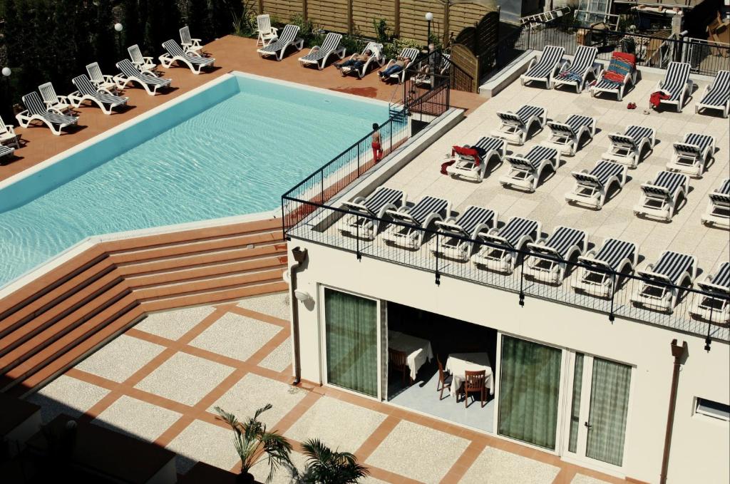 - une vue sur la piscine et ses chaises longues dans l'établissement Hotel Residence Mediterraneo, à Diano Marina