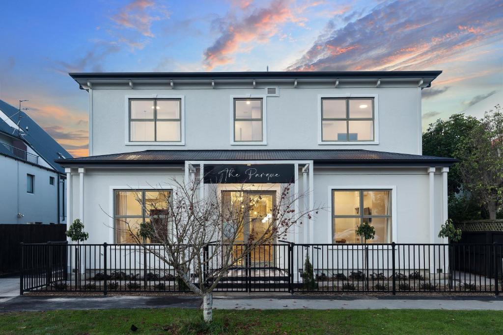 a white house with a black fence in front of it at The Parque in Christchurch