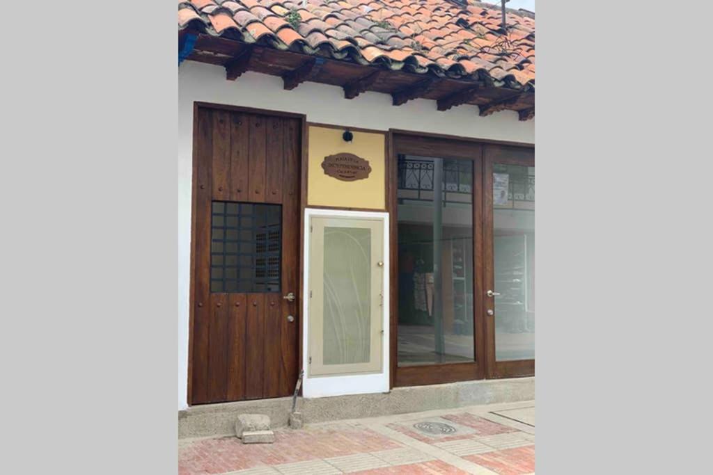 a building with wooden doors and glass windows at Bellisimo chalet en Zona Colonial (302) in Zipaquirá